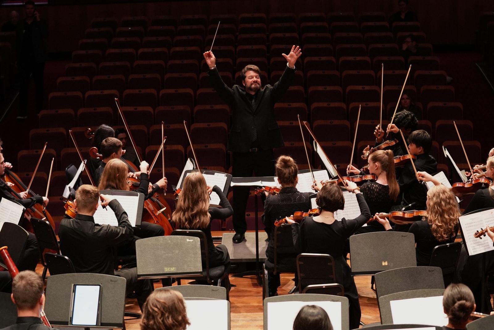 Conductor with arms raised as the bows lift